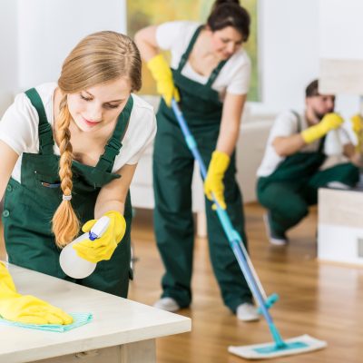 Group of friends as a professional cleaners tiding up big apartment